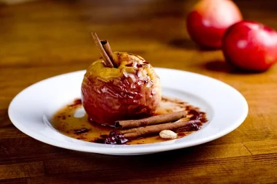 Pommes dorées dans leur plat de cuisson fumant, avec une cuillère de miel qui coule.